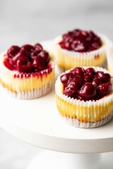 Mini cheesecake with cherry jam. One bite dessert. Tiny cheesecakes with berry. Valentine homemade present. Selective focus.