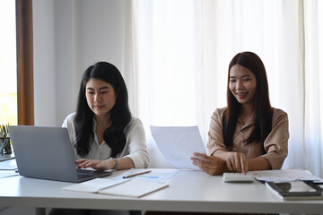 Two female colleagues working together in modern office.