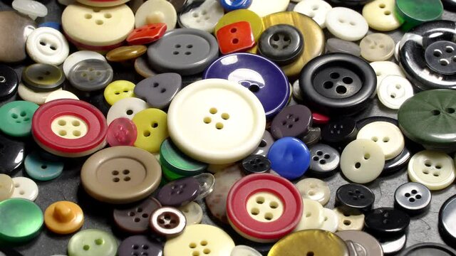 Various plastic sewing buttons rotation background. Close up. Loop motion