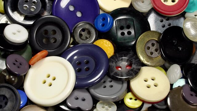 Various plastic sewing buttons rotation background. Close up. Loop motion