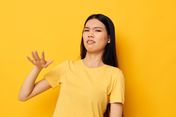 Portrait Asian beautiful young woman in a yellow t-shirt holding his head discontent studio model unaltered