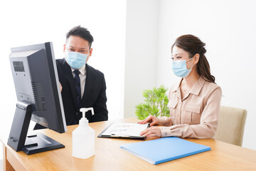 Obraz premium 感染症対策をしてオフィスで働くビジネスパーソン