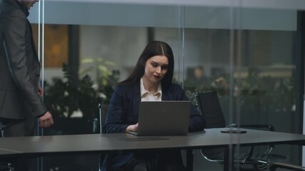 Flirt at workplace. Young businesswoman working on laptop at office, her male colleague coming and caressing her
