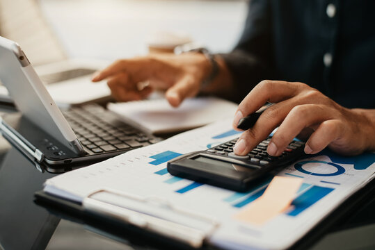 Business man working with tablet and using a calculator to calculate the tax of static in office. Finance accounting concept.