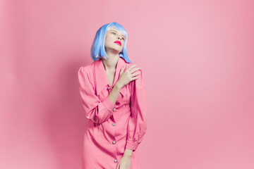 fashionable woman in blue wig pink dress red lips isolated background