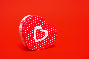 Mockup of a box in the shape of a heart on a red background. Closeup with copy space