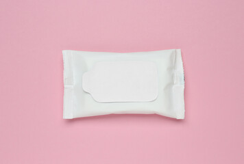 Wet wipes flow pack on pink background, top view