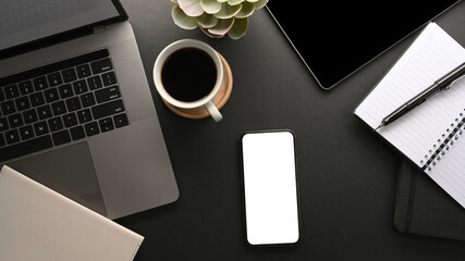 Modern dark workspace with laptop computer and smartphone mockup.