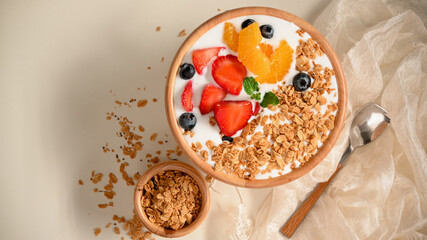 Healthy yogurt bowl with fresh strawberries, blueberries, oranges and granola