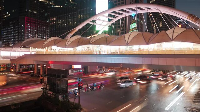 Time-lapse of public skywalk and traffic at night, Bangkok city, Thailand.