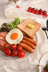 Fototapeta na wymiar Tasty breakfast set serving with egg, sausages, bacons, toasts, salad