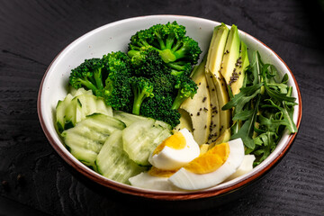 Ketogenic, paleo diet lunch bowl with avocado, cucumber, broccoli and egg. Healthy organic vegan salad. Delicious breakfast or snack, Clean eating, dieting, vegan food concept. top view