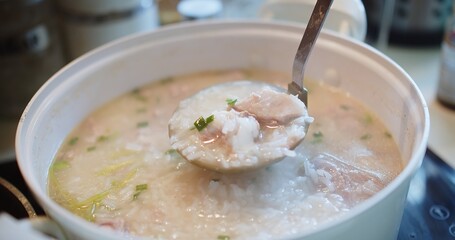 close up cooking stirring and holding Thai style food hot soft boiled rice with Pork Ribs at the kitchen, breakfast healthy food concept	
