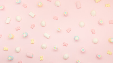 Colorful pattern of sweets on pink pastel background.