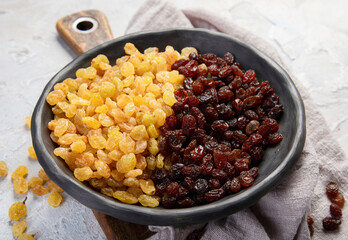 Golden and brown raisins on light  background. Dried Fruits. Top view, flat lay, copy space