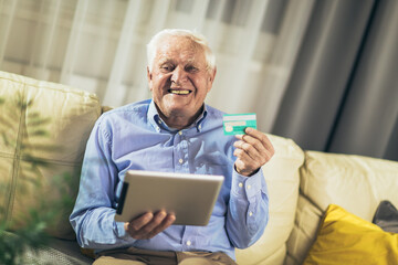 Senior man grandfather shopping online with tablet and credit card at home.