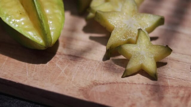 A man's hands take a slice Carambola or starfruit on a wooden board .exotic fruit. Healthy Food. 