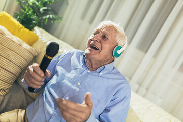 Senior man using microphone and singing karaoke