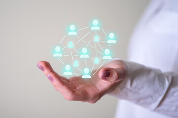 Icons of people and a woman's hand holding everything in her gentle hands.