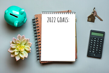 Notepad, piggy bank, calculator, glasses, pen on gray background Financial planning, goals for New Year concept Top view Flat lay Finance training and strategies Copy space