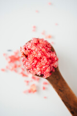Close-up of sea bath salts on a ceramic spoon. View from above
