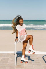 beautiful black woman posing on roller skates on the beach