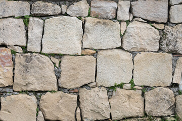 Background of brown-gray stone wall with leaves and moss . Pattern of slate wall texture and background