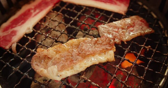 Close up juicy fresh roasted grilled meat beef sliced on charcoal grill at Japanese restaurant, yakiniku Japanese style food