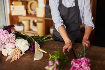 Florist picking up flowers for pink tender bouquet