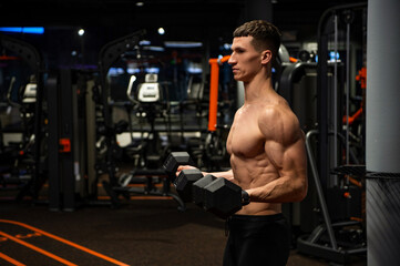 Naklejka premium Shirtless man doing bicep tricep curls with dumbbells in gym, strength workout