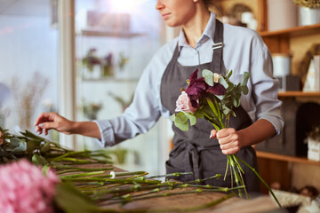 Florist picking up flowers for pink tender bouquet