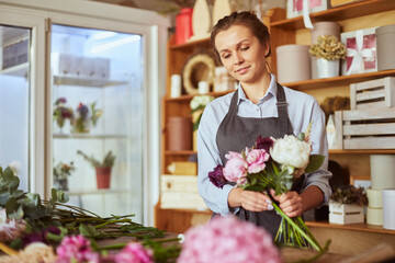 Florist arranging flowers for pink tender bouquet