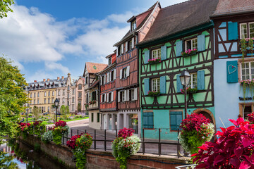 Fototapeta na wymiar Flower beds along the city canal in the center of the medieval city of Colmar. Floral decoration of an ancient city. Alsace, France