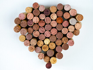 Wine used corks shape heart on a white background. Top view, copy space. High quality photo