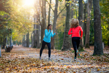 Woman Exercising in Public Park with Personal Trainer. Trainer Cheering and Woman Running