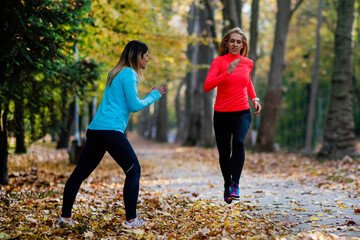 Woman Exercising in Public Park with Personal Trainer. Trainer Cheering and Woman Running