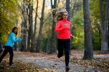 Woman Exercising in Public Park with Personal Trainer. Trainer Cheering and Woman Running