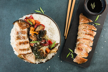 A bowl with rice, grilled vegetables and teriyaki chicken