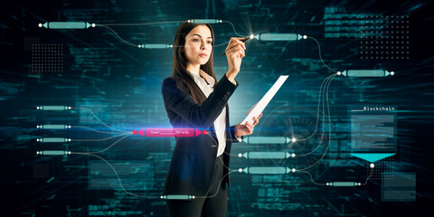 Attractive young caucasian businesswoman using abstract glowing big data blockchain interface on dark background. Cryptocurrency, finance, big data and information concept. Double exposure.