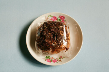 close up chocolate donut flavour on plate with plastic pack