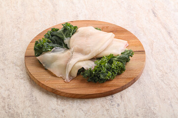 Raw squid over wooden board