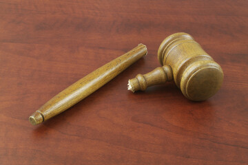 Broken wooden judge gavel on table. Concept of iniquity, injustice and not working laws.