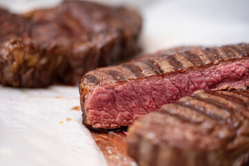 Close-up Sliced grilled beef steak. Delicious juicy meat steak cooking on grill on white background, top view