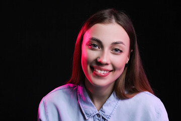 Portrait of young woman on dark color background