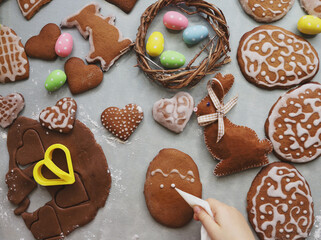 Girl makes homemade gingerbread cookies for Easter