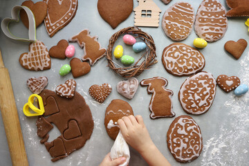 Girl makes homemade gingerbread cookies for Easter