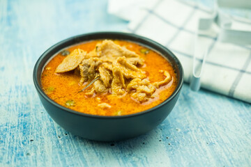 Red pork curry (Panang) in black bowl. Thai food
