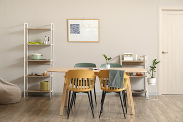 Interior of light dining room with table and shelving units
