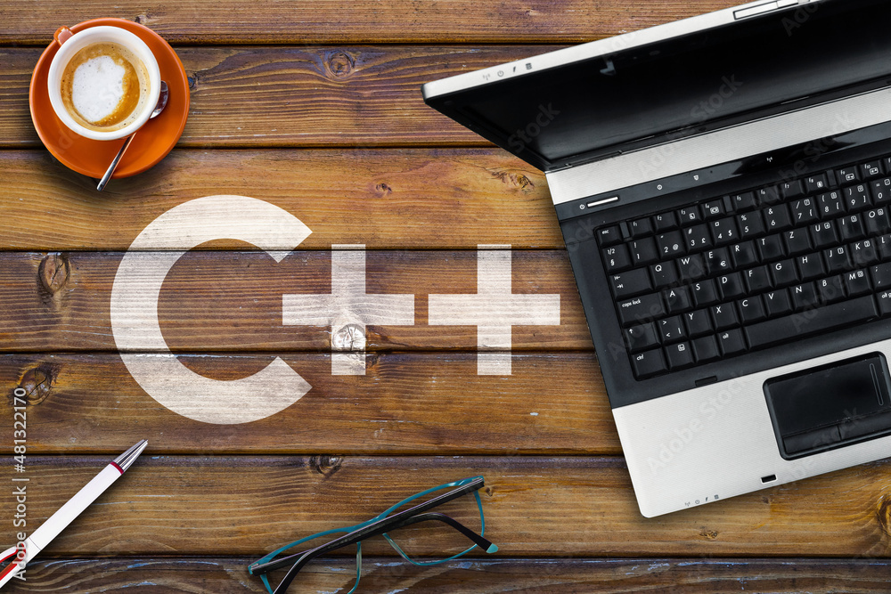 Poster c plus programming language. word c++ on wooden desk and laptop