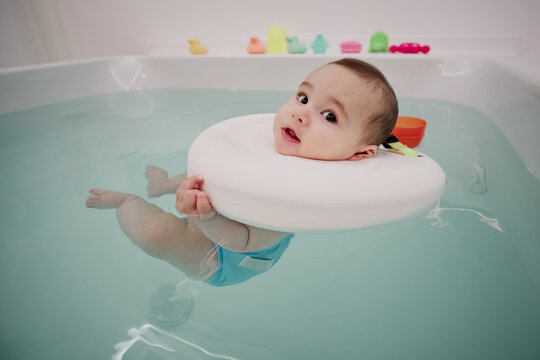 Baby enjoying in the jacuzzi. Spa for babies. Hydrotherapy session for children. Baby swimming